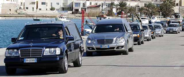 Hearses with the remains of migrants who died in a shipwreck arrive at the Lampedusa harbour