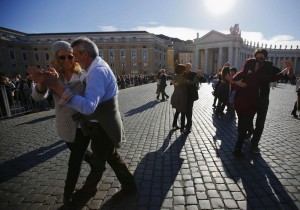 Couples dance in front of Saint Peter's basilica at the Vatican