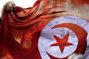 A person holds up a Tunisian flag and shouts slogans during celebrations marking the fourth anniversary of Tunisia's 2011 revolution, in Tunis