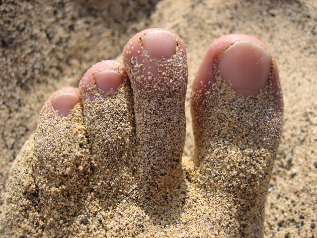 Foot with sand in a beach.