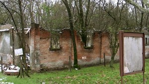A building at the entrance to the Fossoli Concentration Camp is overrun with vegetation