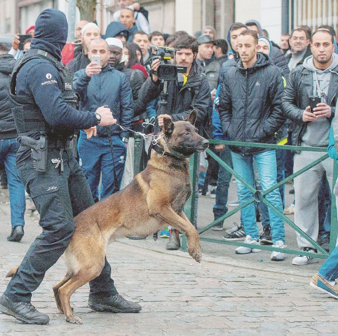 Diffidenze e integrazione - I giovani di Molenbeek osservano la polizia durante il raid per la cattura di Salah;