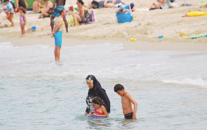 Tutti al mare - Una donna musulmana al mare con il costume delle osservanti