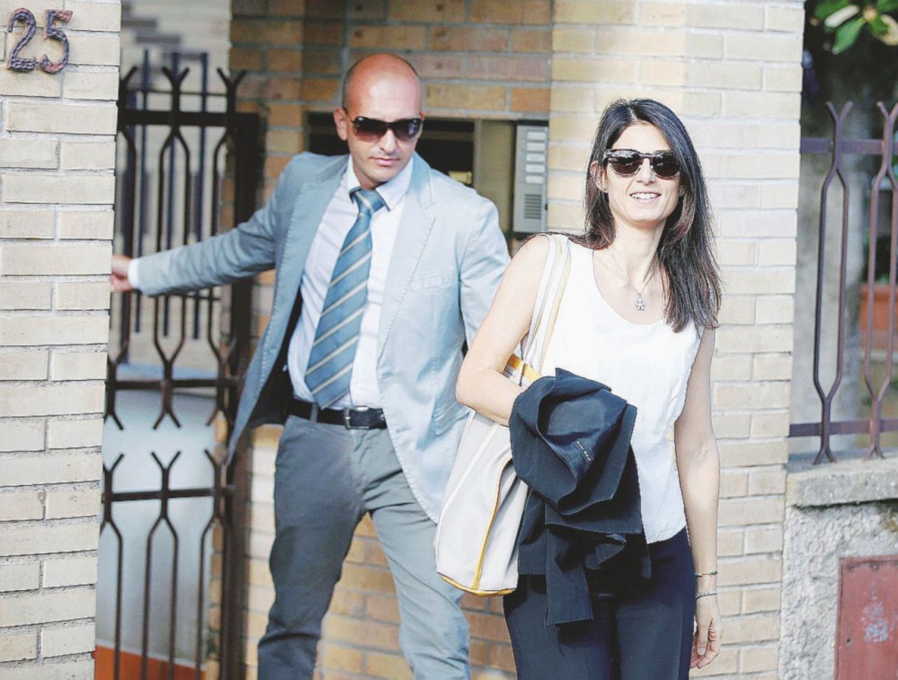 La regola è: mai sola  -   Virginia Raggi esce di casa con uno degli agenti che la accompagnano in ogni suo spostamento - Ansa