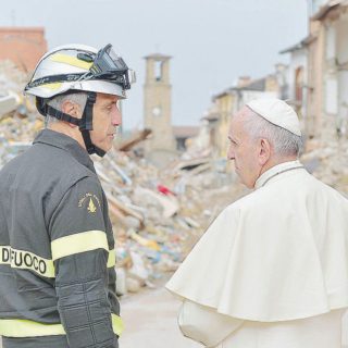 Papa Francesco con un vigile del fuoco tra le macerie del centro  di Amatrice  - Ansa