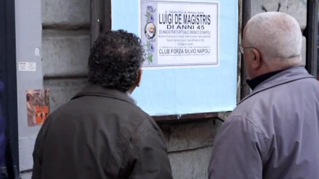 Copertina di Pesce d’aprile, Club Forza Silvio tappezzano Napoli con De Magistris “morto”