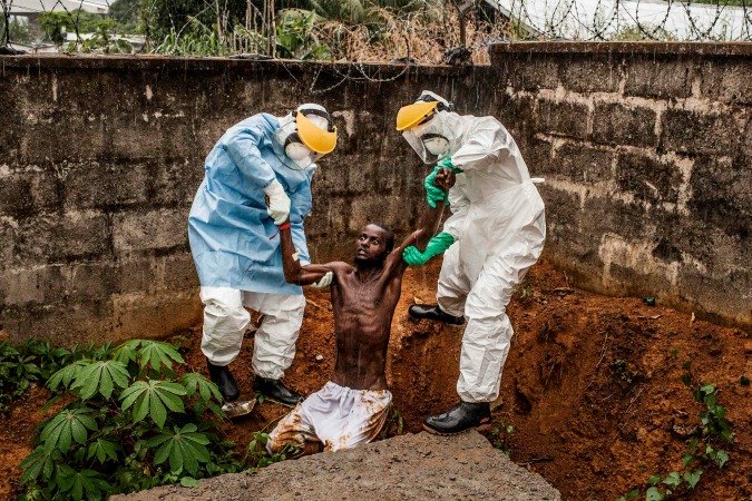 Pete Muller (Prime) – Primo premio nella categoria General News, Stories – Due sanitari di un centro per la cura contro Ebola di Freetown, in Sierra Leone, trattengono un uomo, affetto dal virus, in preda al delirio