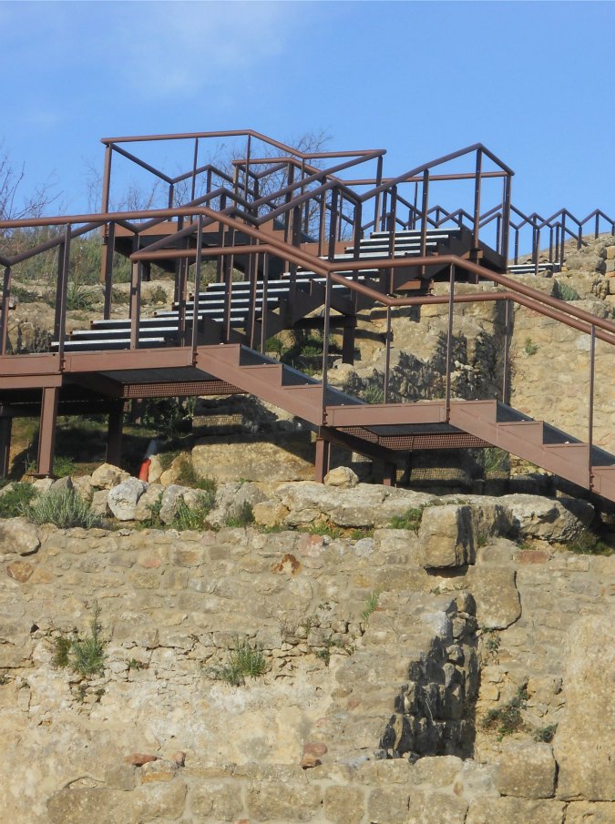 Copertina di Area archeologica Morgantina, scala di ferro per i turisti tra i resti antichi. “Uno scempio”