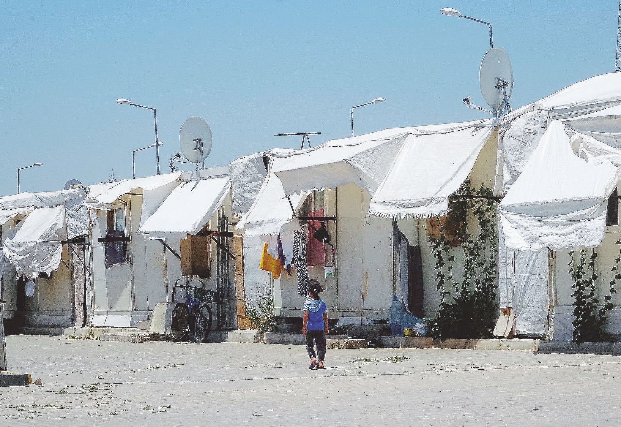 Un campo profughi. A sguire, la tessera per gli acquisti e una ragazza al telaio - Curzi In Turchia con i siriani “Non torneremo a casa”