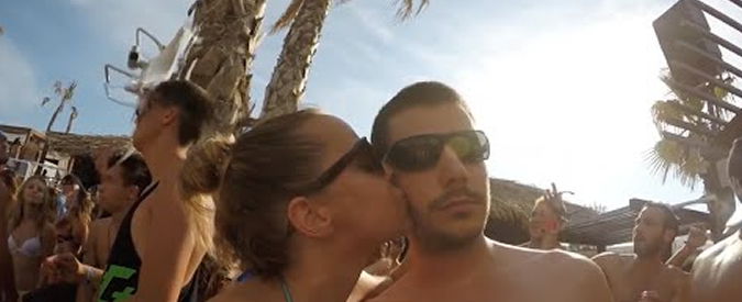 Copertina di Festa in spiaggia, una coppia si riprende con il cellulare e dietro di loro accade qualcosa di assurdo