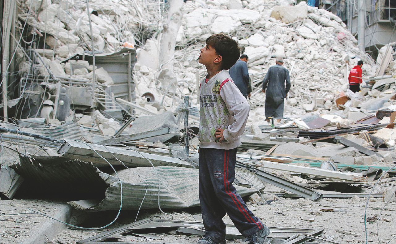 Un bambino di Aleppo fra i palazzi sventrati dopo l’ennesimo bombardamento - Ansa I bambini di Aleppo e il film dell’orrore: altri cento morti