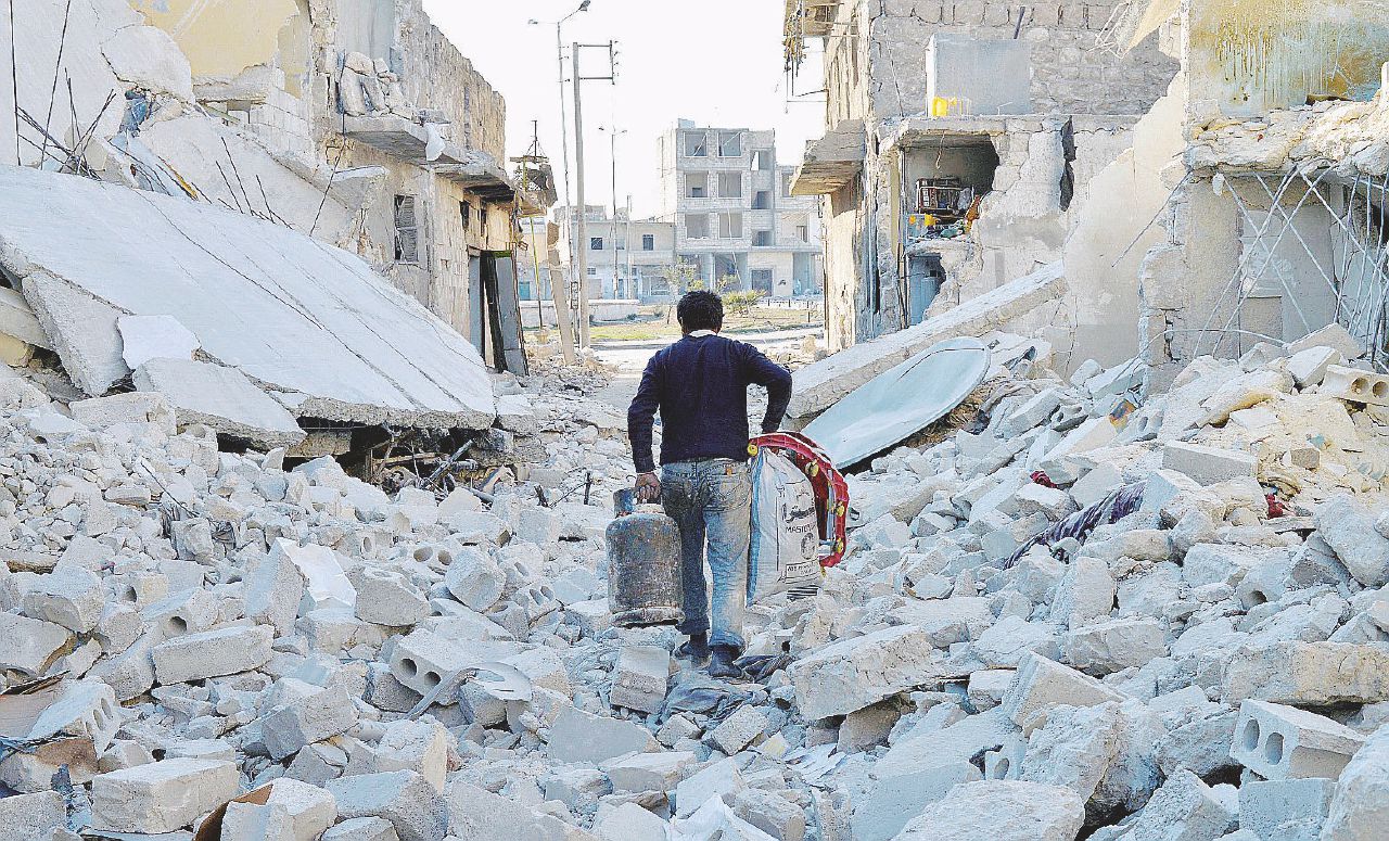 La fatica di sopravvivere - Un uomo torna a casa con le scorte attraverso una delle strade in macerie di Aleppo - Ansa “Ormai è #Holocausto Aleppo”