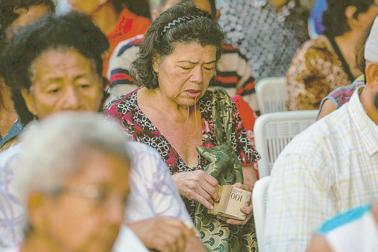 In fila - Donne con biglietti da 100 Bolivar dinanzi alle banche - Ansa Caracas anno zero, le donne si vendono i capelli