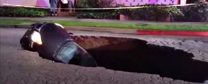 Copertina di Maltempo a Los Angeles, una voragine in strada inghiotte due macchine