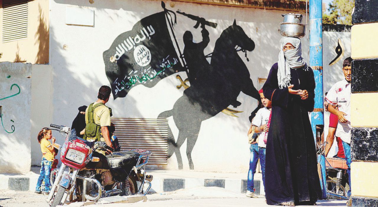Simbolo in declino - Un murales con il vessillo dell’Isis a Jarablus, città siriana al confine con la Turchia. Sono almeno 3 milioni i profughi che vivono nell’area di frontiera - LaPresse La minaccia del terrorismo islamico durerà più a lungo del potere dello “zar”