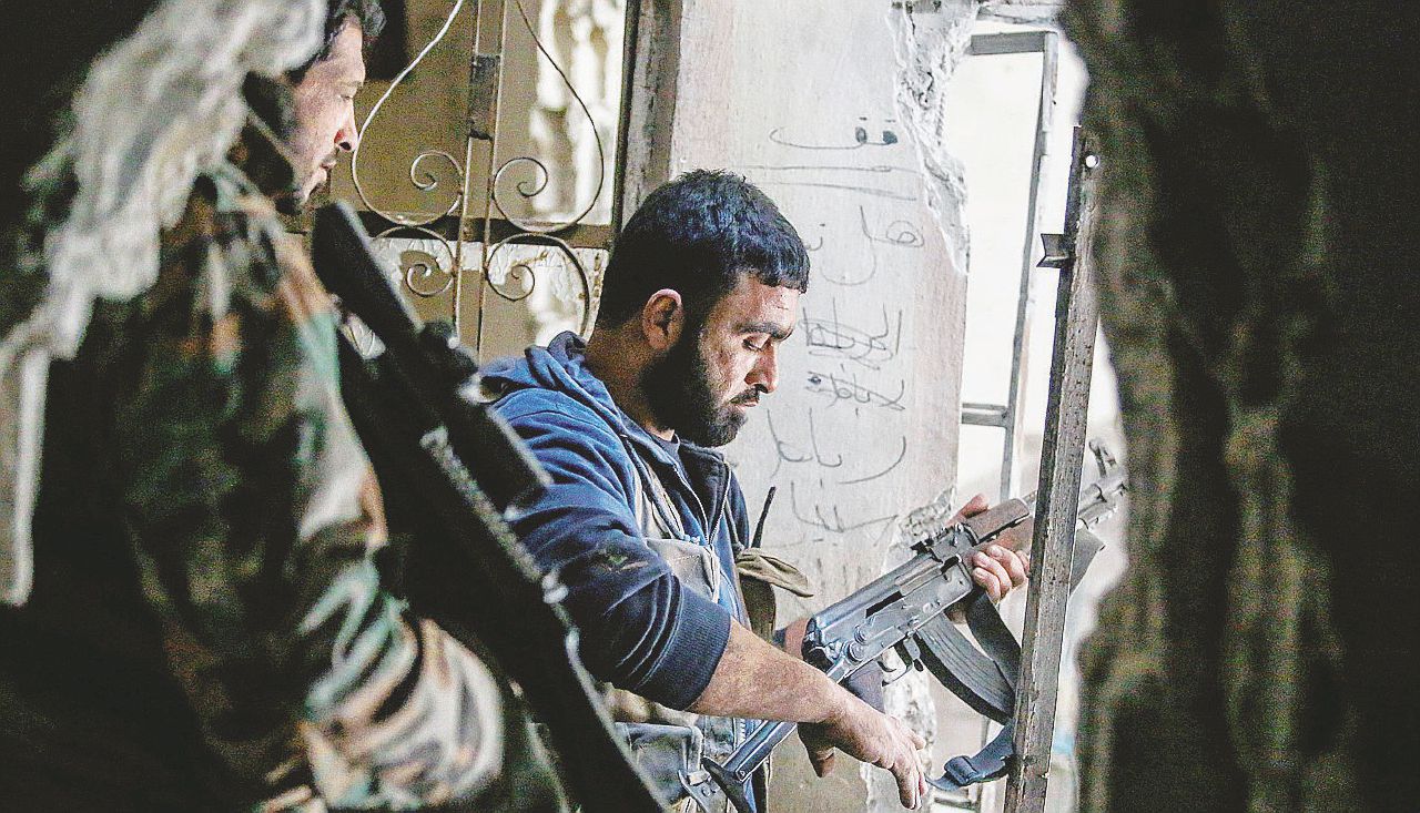Fucili spianati - Una pattuglia di ribelli anti Assad nella zona di Teshreen, vicino Damasco - Ansa I ribelli temono di essere sacrificati nel Risiko siriano