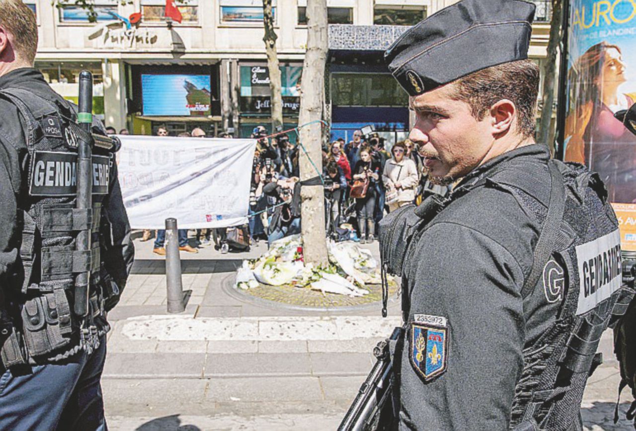 Gendarmi rendono omaggio all’agente ucciso, Xavier Jugele - Ansa Fiori, fotografie e soste al caffè: vivere e morire sugli Champs-Élysées