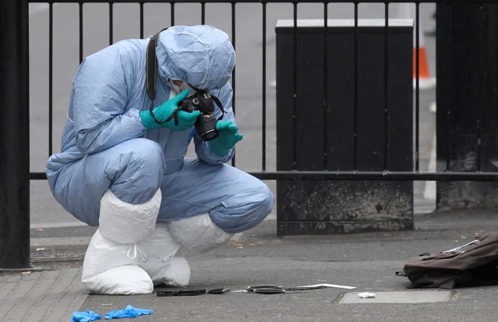 A forensics investigator photographs knives on the ground after man in Westminster after an arrest was made on Whitehall in central London, Britain, April 27, 2017. REUTERS/Toby Melville