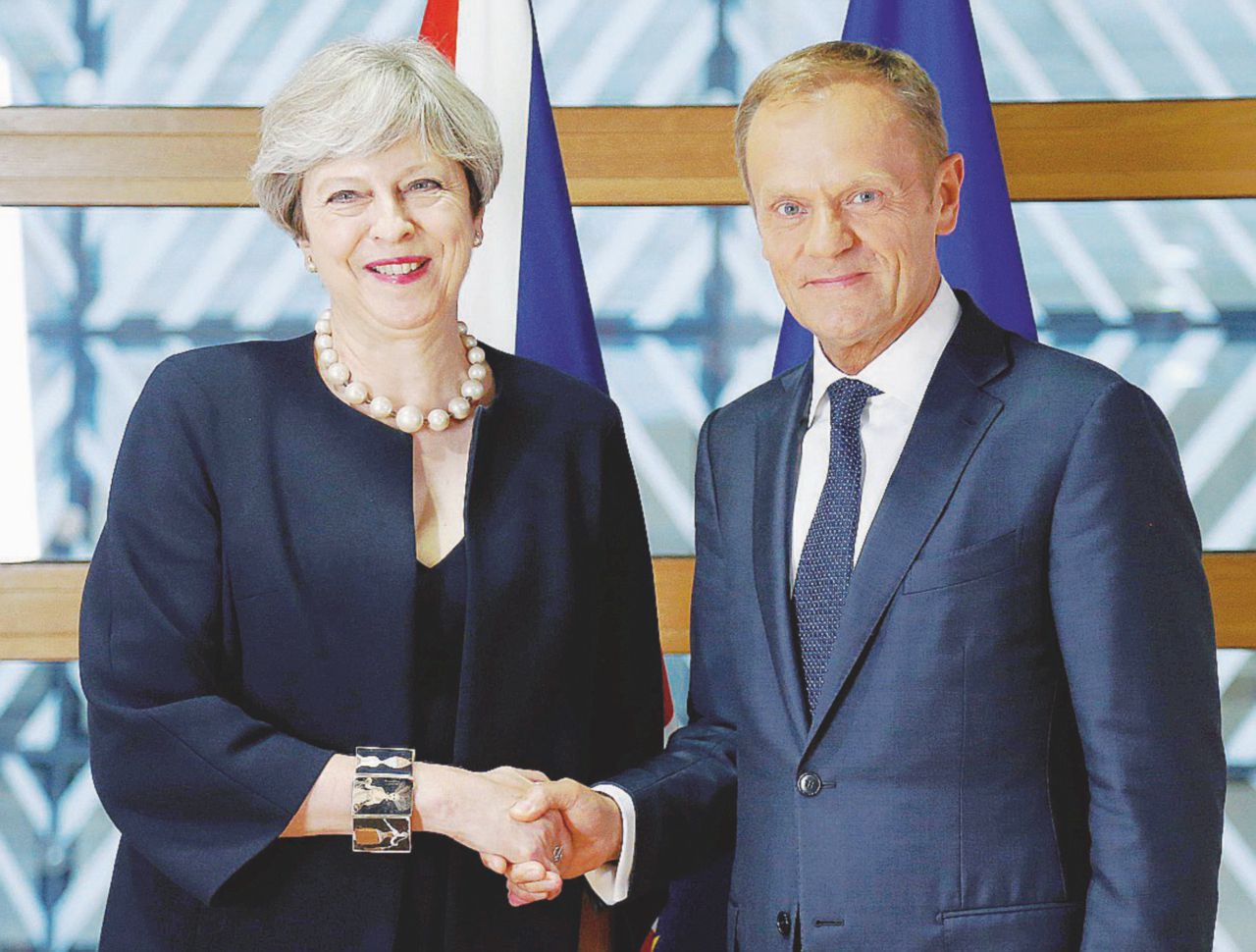 La premier barcollante - Stretta di mano tra Theresa May e il presidente del Consiglio europeo, il polacco Donald Tusk - Ansa Un anno dopo il coltello Brexit lo ha in mano la Ue
