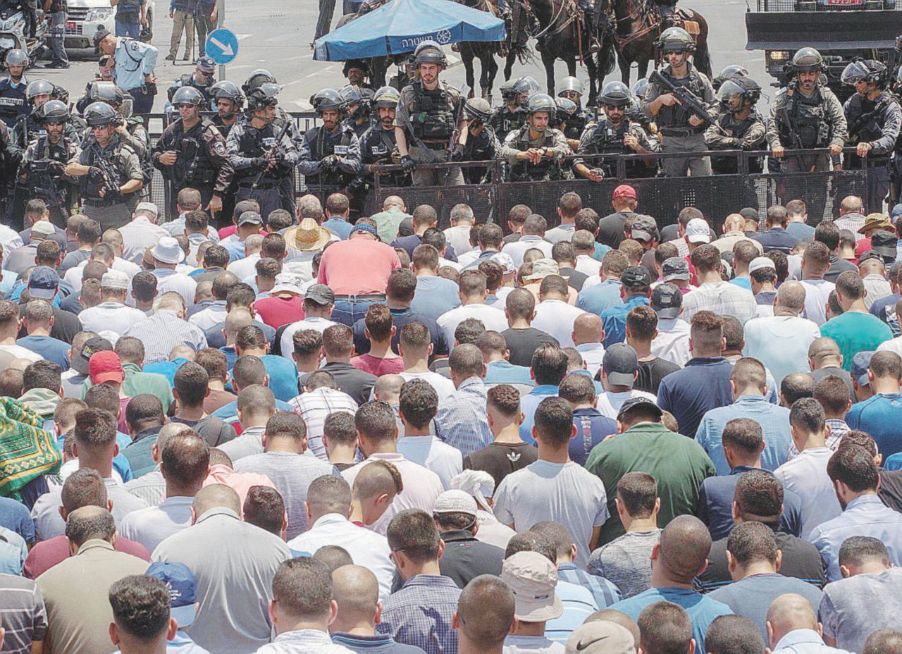 Venerdì sulla Spianata - Un gruppo di fedeli musulmani prega di fronte ai soldati dell’esercito israeliano - Ansa È la Spianata delle preghiere ma per averla si massacrano