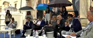 Copertina di Ministro e presidente Regione Pd seduti a parlare, ragazze li proteggono da pioggia con ombrello. Polemica in Abruzzo