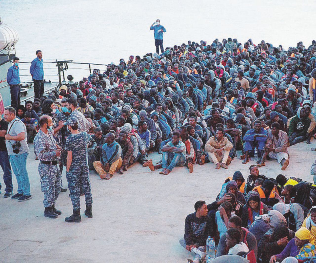 Un gruppo di migranti sotto il controllo delle forze libiche nel porto di Tripoli - Ansa Il palazzo vuoto dell’Onu a Tripoli attende i rifugiati