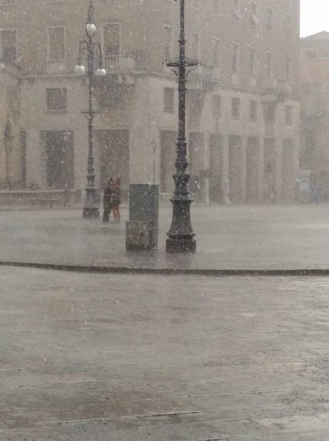 Lecce, il bacio dei fidanzati sotto il diluvio nella piazza deserta. Il fotografo: “Non li conosco, ma li trovo bellissimi”