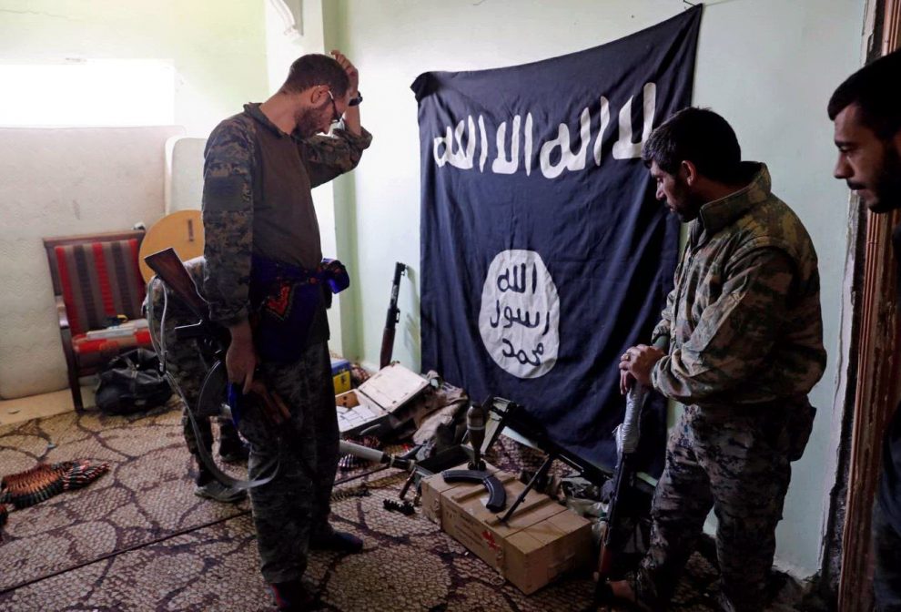 Membri delle Sdf ispezionano armi e munizioni trovate in un rifugio Isis