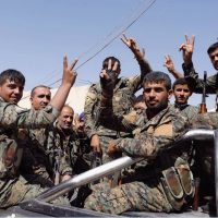 Combattenti delle Forze Democratiche Siriane fanno il segno della vittoria