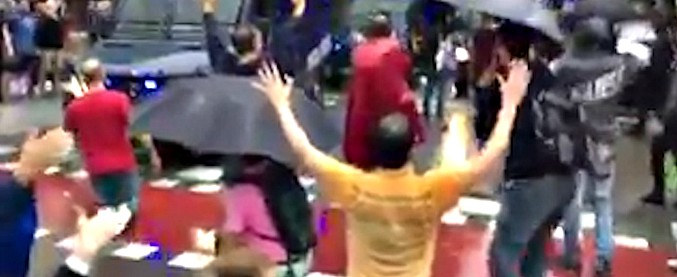 Copertina di Referendum Catalogna, persone in strada con le braccia alzate cercano di bloccare i mezzi della polizia