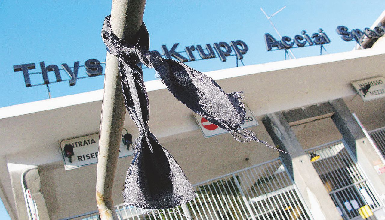 Drappo nero alla Thyssen di Torino; sotto, i condannati Harald Espenhahn e Gerald Priegnitz - Ansa La Procura scrive ai tedeschi “Arrestate i capi di Thyssen”