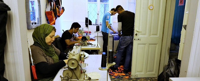 Copertina di Lesbo, la sartoria che dà lavoro ai migranti: “Così recuperiamo i giubbotti salvagente e li trasformiamo in borse”