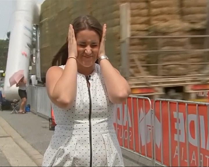 Copertina di Che disastro! E la giornalista si mette le mani nei capelli. Ecco cosa è successo alla partenza della gara ciclistica