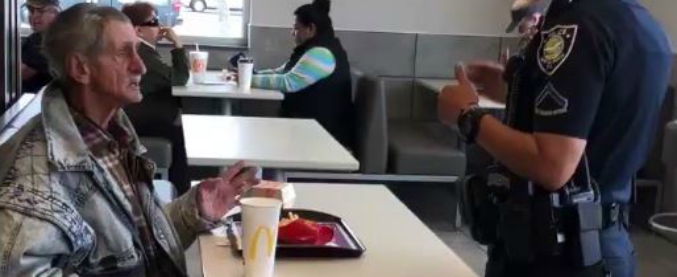 Copertina di Offre il pranzo a un senzatetto: la polizia caccia entrambi dal locale. E il video diventa virale: “Fate schifo”