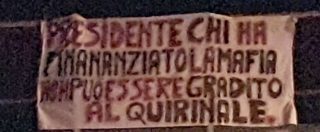 Copertina di Capaci, lo striscione contro Berlusconi dove fu ucciso Falcone: “Ha finanziato la mafia. Non può essere al Quirinale”
