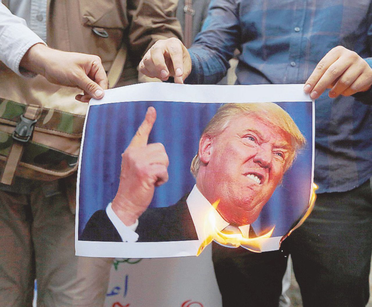 Ritorno al passato - Manifestanti davanti all’ex ambasciata americana a Teheran bruciano una foto di Trump - LaPresse Con le sanzioni si fermano gli investimenti italiani in Iran e lo Stato rischia 5 miliardi