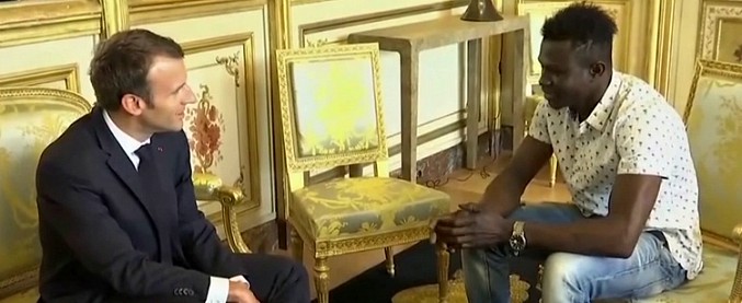 Copertina di Parigi, l’incontro tra il presidente Macron e il migrante-eroe: “Raccontami come hai salvato il bambino”