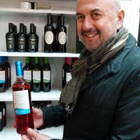 Giuseppe Coppola con una bottiglia dei suoi vini pregiati.