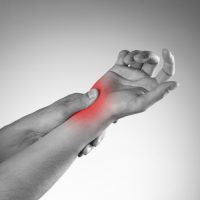 Pain in the joints of the hands. Carpal tunnel syndrome. Black and white photo with red dot