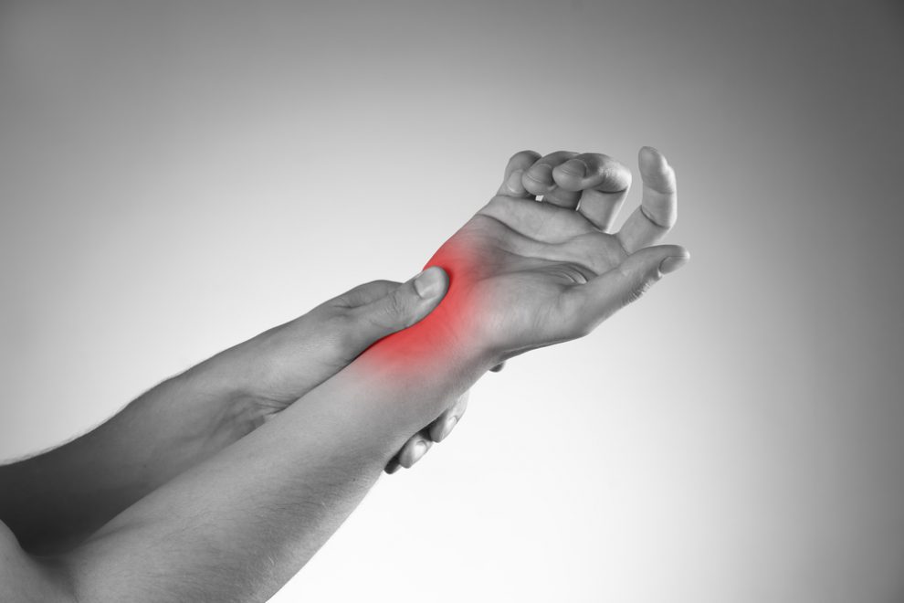 Pain in the joints of the hands. Carpal tunnel syndrome. Black and white photo with red dot