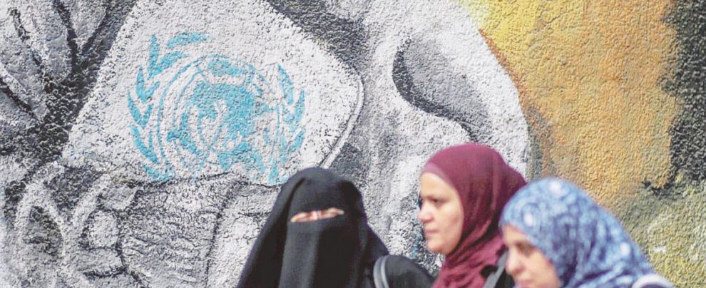 In ginocchio - Donne palesinesi sotto al Muro costruito da Israele per dividere i Territori Quanti guai: Trump così lascia a secco gli aiuti a Ramallah