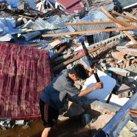 An Indonesian man breaks rubbles as he searches for a family member at their damaged house in the Balaroa village in Palu, Indonesia’s Central Sulawesi on October 1, 2018. – The death toll nearly doubled to 832 but was expected to rise further after a disaster that has left the island of Sulawesi reeling. (Photo by ADEK BERRY / AFP)