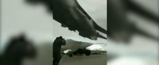 Copertina di Il cacciabombardiere sbuca dal nulla e sfiora l’uomo sulla pista: il volo a pochi metri dal suolo è impressionante