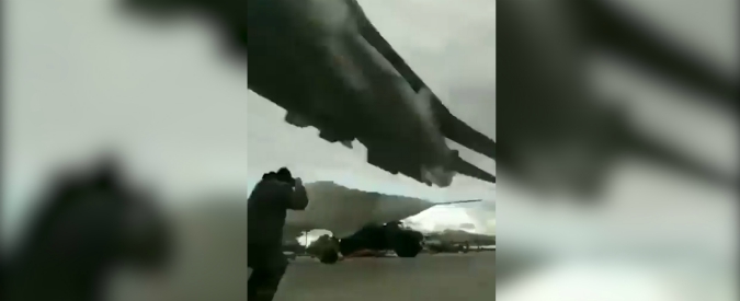 Copertina di Il cacciabombardiere sbuca dal nulla e sfiora l’uomo sulla pista: il volo a pochi metri dal suolo è impressionante