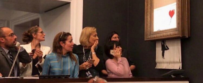 Copertina di Appena battuta all’asta per 1,2 milioni di dollari, l’opera di Banksy si autodistrugge: il tritacarte nascosto nella cornice