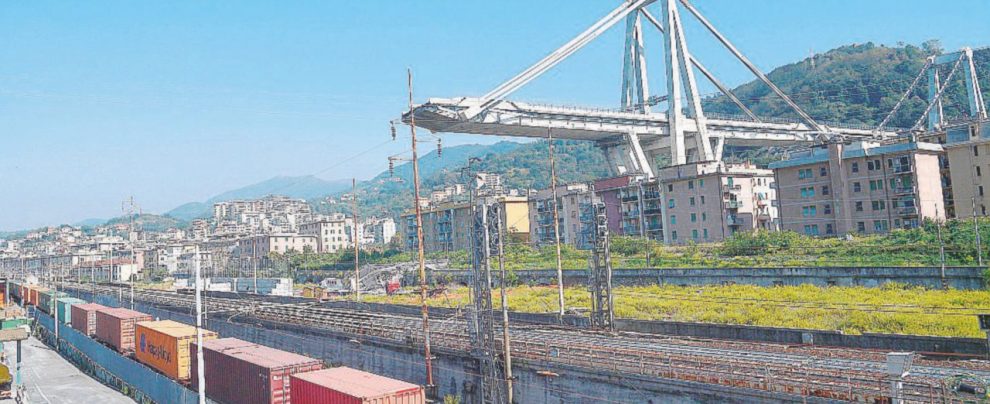 Un treno merci passa vicino a quel che resta di ponte Morandi, a Genova - Ansa Genova, per il ponte tornano in corsa Gavio, l’Anas e Toto
