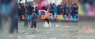 Copertina di Venezia, giovani si “tuffano” e fanno il bagno nell’acqua alta di piazza San Marco. E i turisti li filmano sorpresi