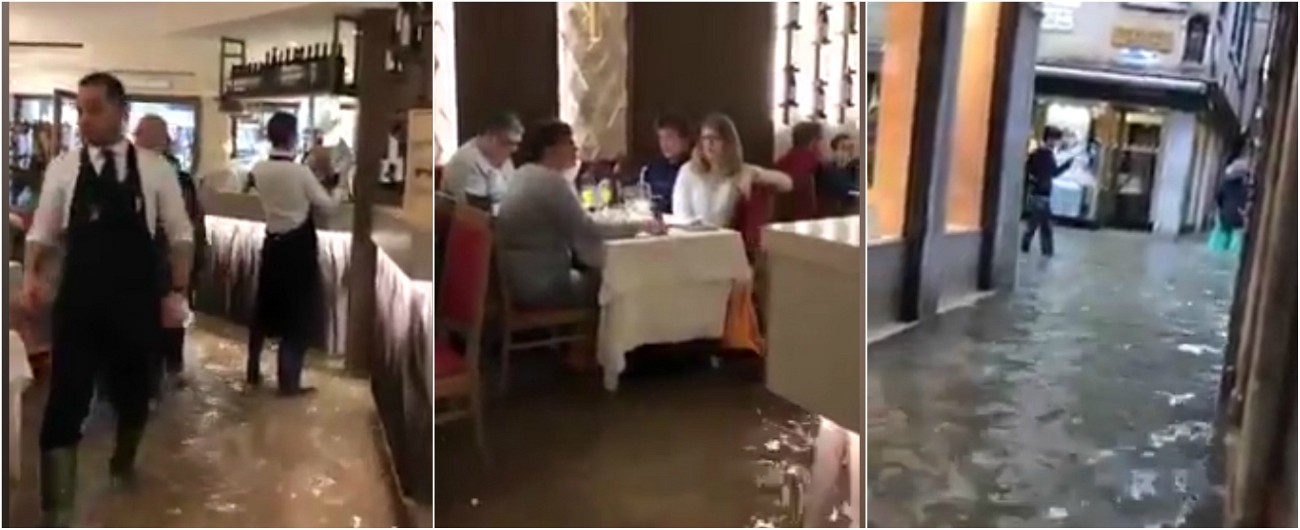 Copertina di Venezia, l’acqua alta non ferma la voglia di pizza. Camerieri e clienti con i piedi a mollo