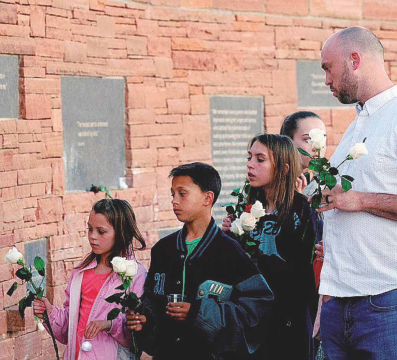 Flagello delle armi - Un sopravvissuto porta fiori alla lapide che ricorda le vittime - Ansa Columbine, il massacro che non è mai finito