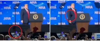 Copertina di Donald Trump si avvicina al microfono e un uomo gli lancia il cellulare: l’episodio alla convention sulle armi